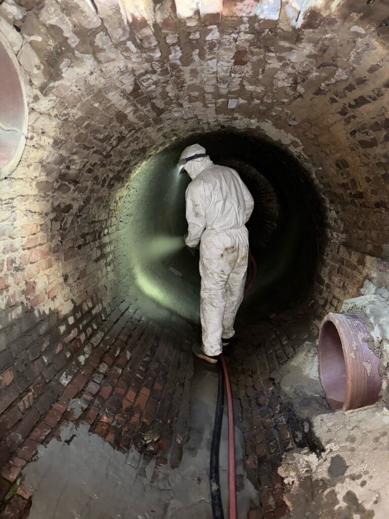 PEAK crew member rehabilitating a large pipe